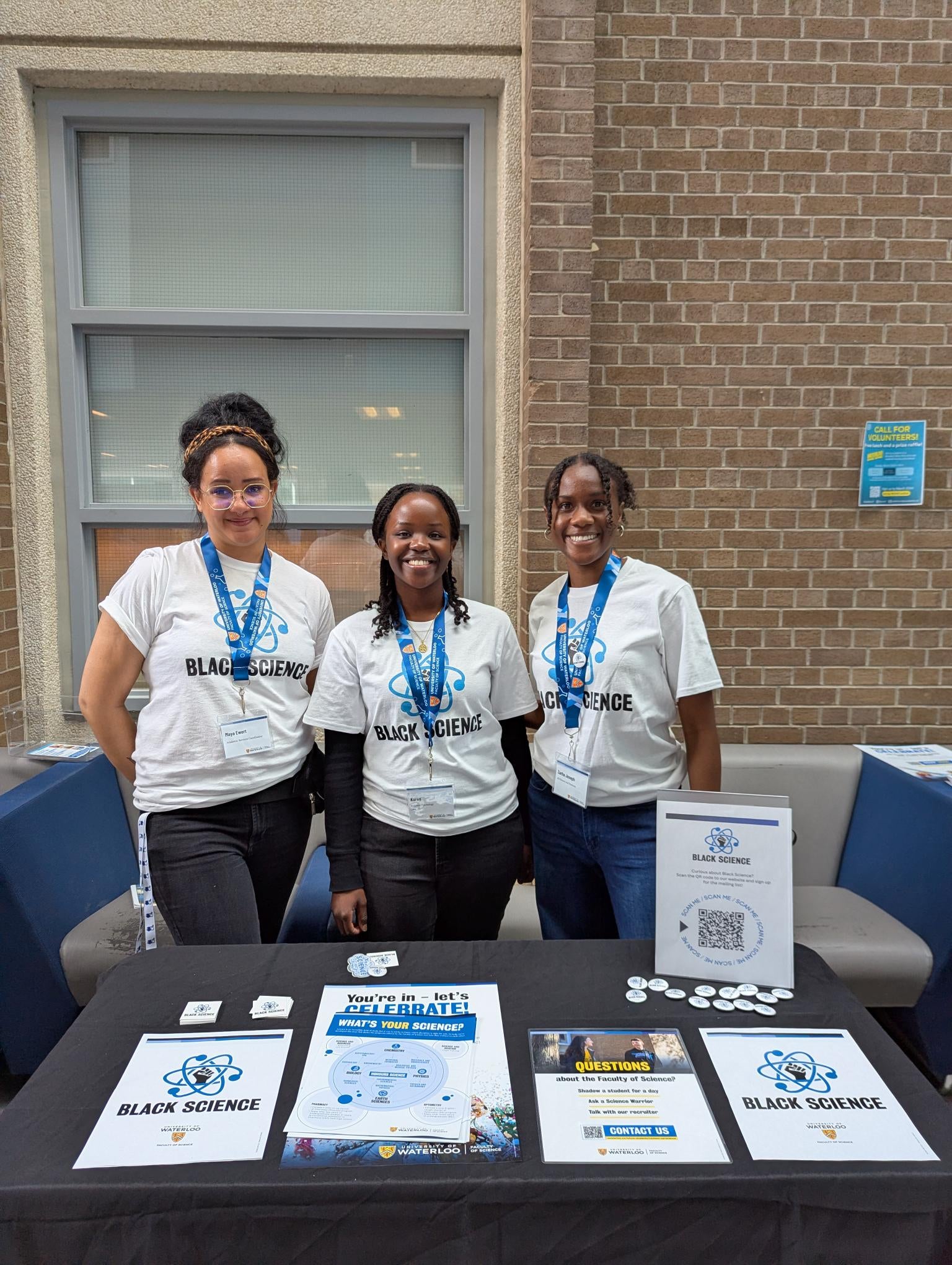 3 Black Science members setting up an information table