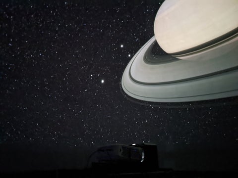 Saturn has an overall hazy yellow-brown appearance against a dark universe. 