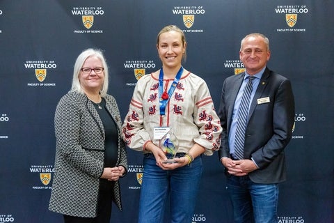 Olga Shmaidenko holding her award, beside Chris Houser and Kirsten Muller