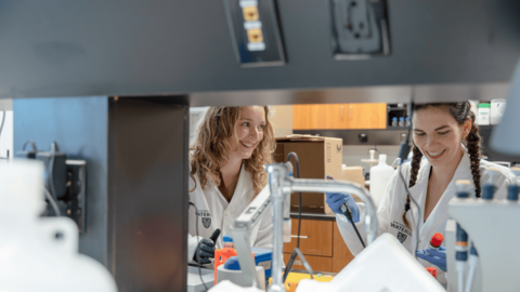 Anne Hambly and Annemarie Dedek conducting research in a lab