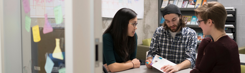 Three students studying together at a table. 