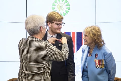 Ben Woodward being presented with the King Charles III Coronation Medal at a ceremony.