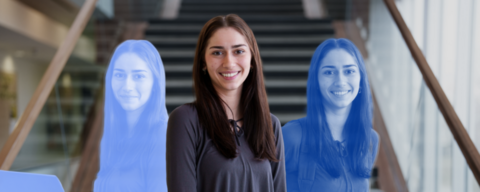 Milena Gojsevic, a Biochemistry student in a long hallways with stairs in the background.