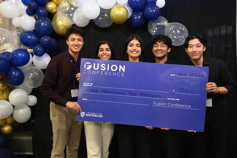 A University of Waterloo team holding a large cheque - the prize for winning the Fusion conference.