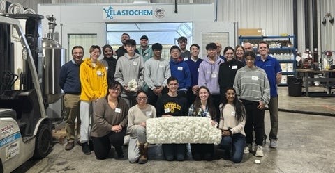 Group of students at Elastochem company, holding a piece of spray foam insulation