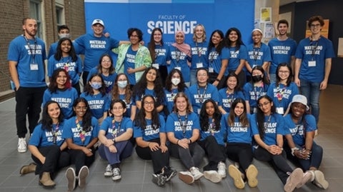 Science Ambassadors posing as a group in Science blue t-shirts in front of a Waterloo Science banner.