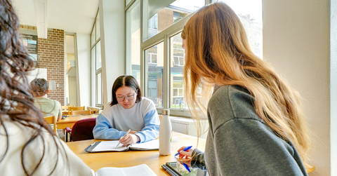 Two students studying together at a table. 