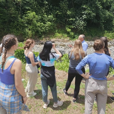 A group of students talking in a rainforest