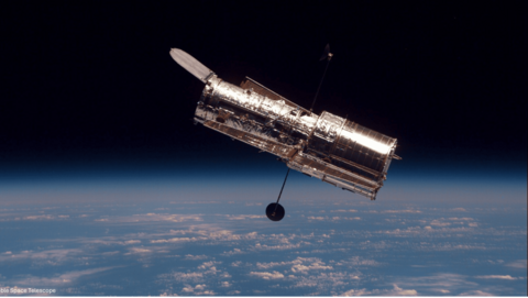 A telescope orbiting over Earth.