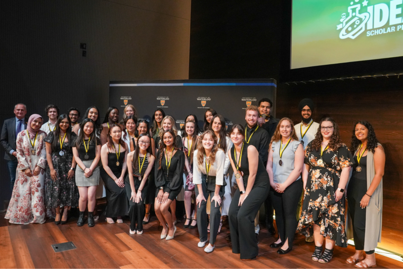 IDEAL Scholars (a diverse group of students) pose in front of a University of Waterloo Science banner.