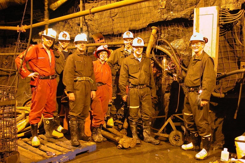 Shaun Frape and 6 other students and collaborators dressed in hard hats and coveralls, and down a mine shaft