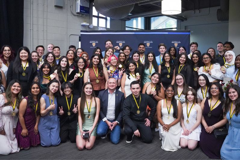Dean Chris Houser kneeling in the middle of a large group of IDEAL Scholar students.