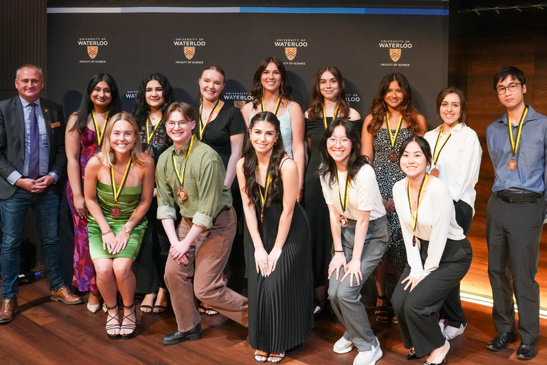Dean Chris Houser standing next to a group of bronze IDEAL Scholar students.