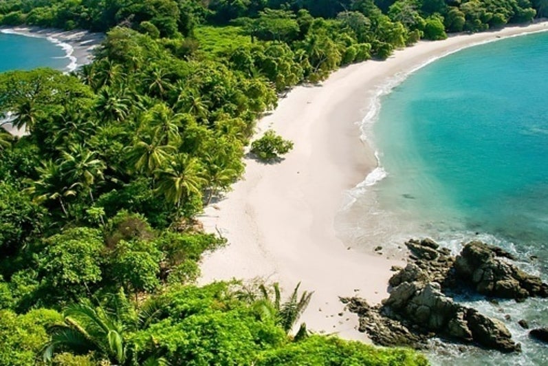 Aerial view of turquoise blue water lapping up on a Costa Rican beach