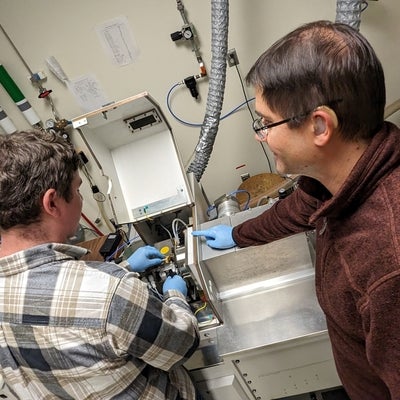 Dr. Brian Kendall working on a experiment with a student in the lab.