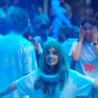 A girl wearing lab goggles covered in blue powder
