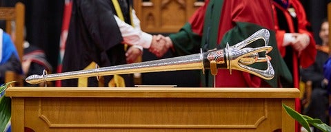 Waterloo convocation ceremonial mace laying on a wooden table.