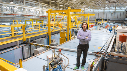Professor Dmitry Pushin standing in an industrial looking lab space