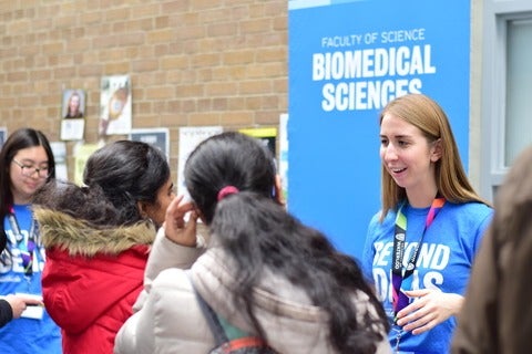 Science ambassador talking to prospective students at the fall open house.