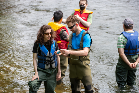 Students and instructors in waders standing in the Grand River