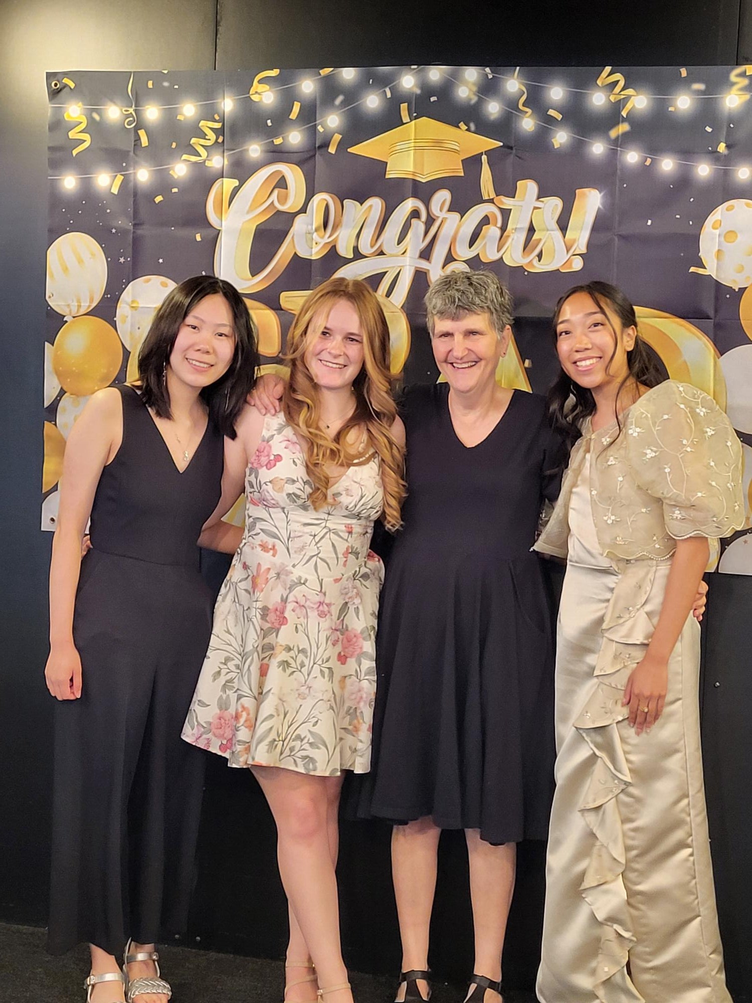 Chemistry students posing with professors of Chemistry in front of a graduation sign. 