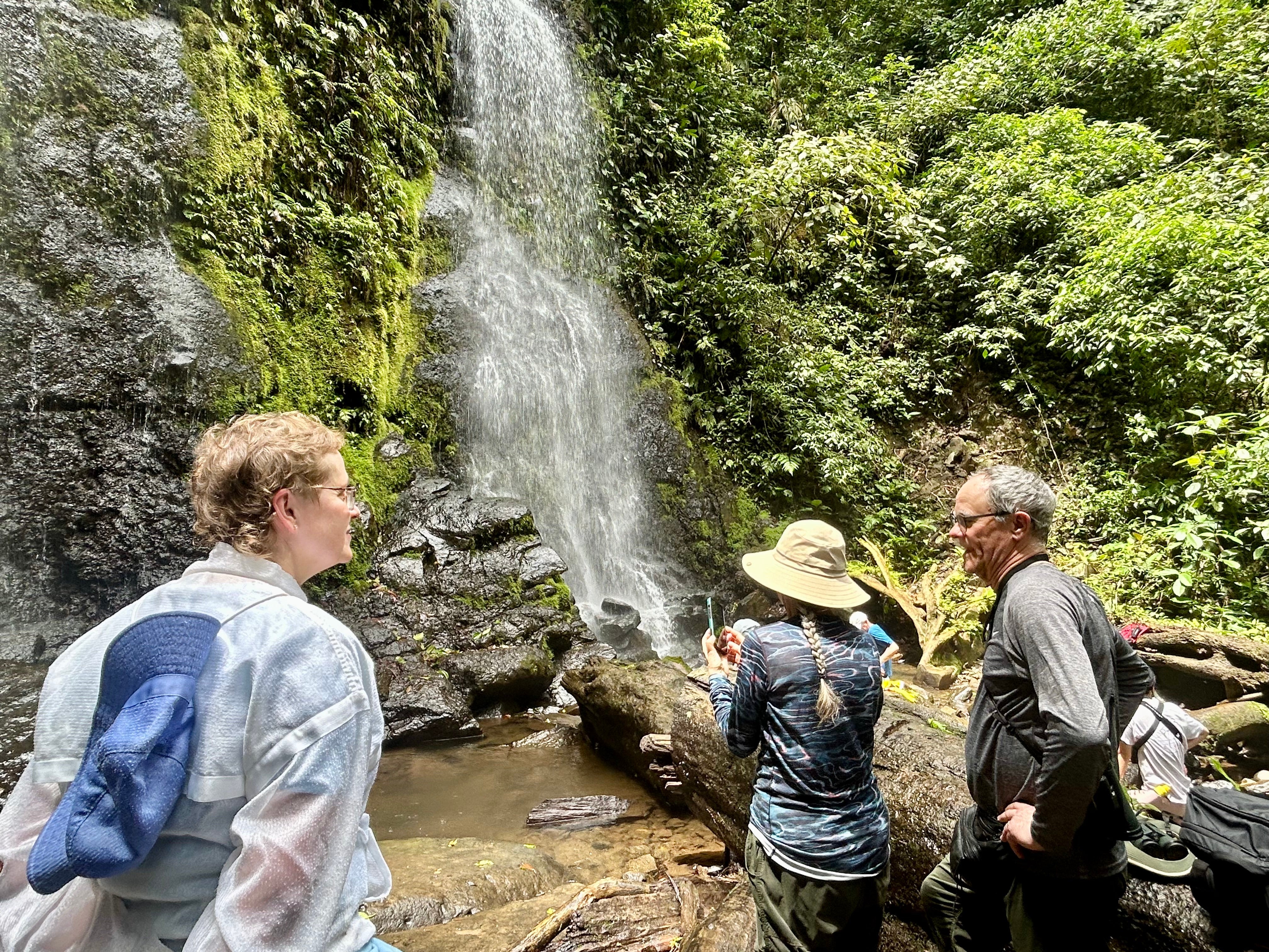 Alumni gathered at the base of a waterfall