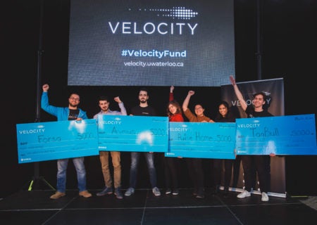 Four Velocity Fund $5K competition winners holding their cheques.