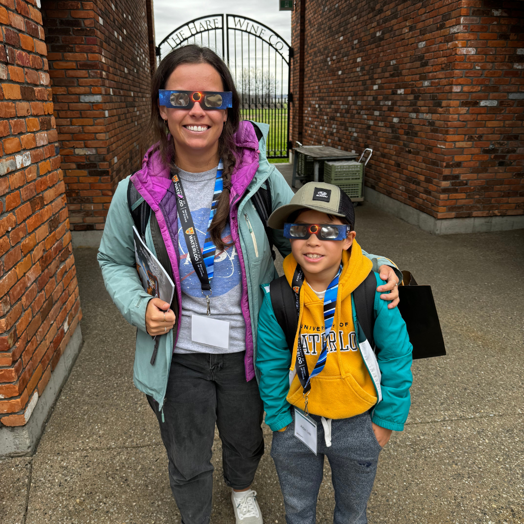 A women and young child wearing solar eclipse glasses.