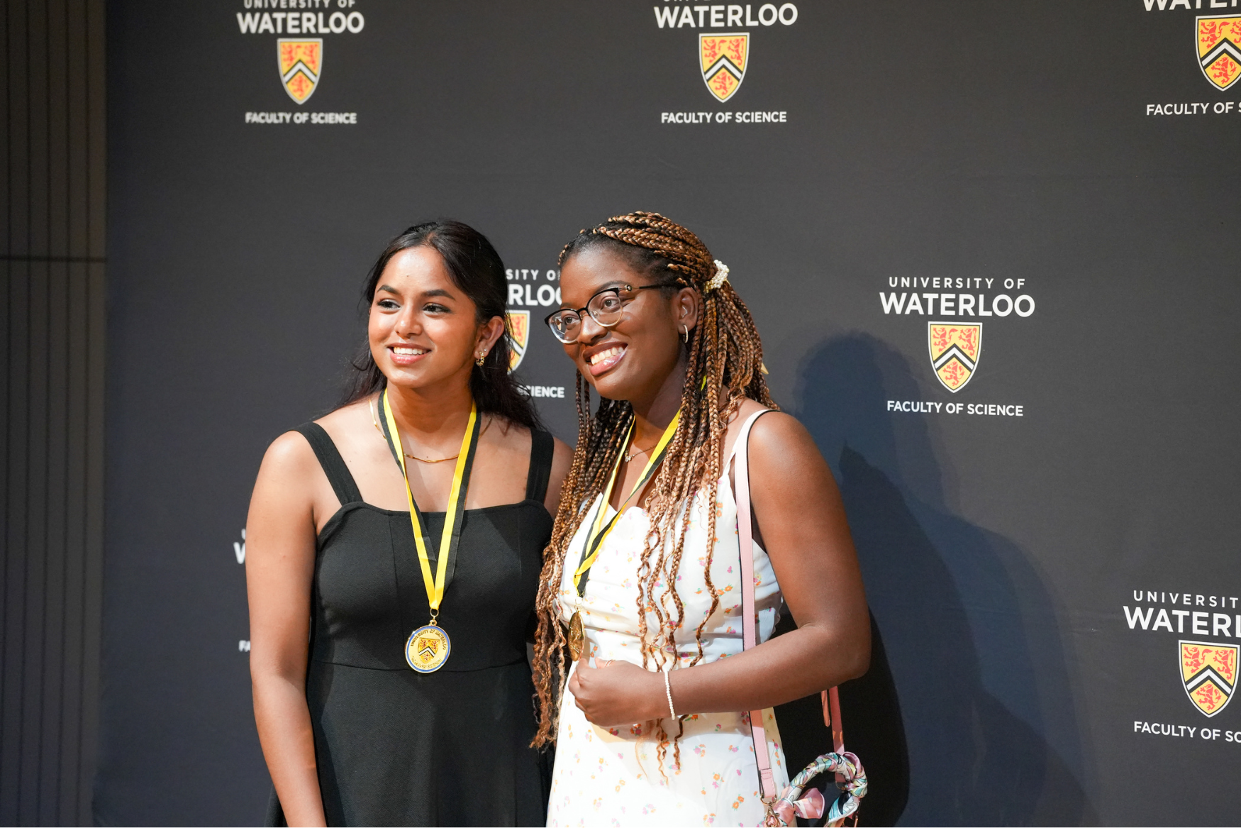 Two IDEAL Scholars pose in front of a University of Waterloo Science banner.