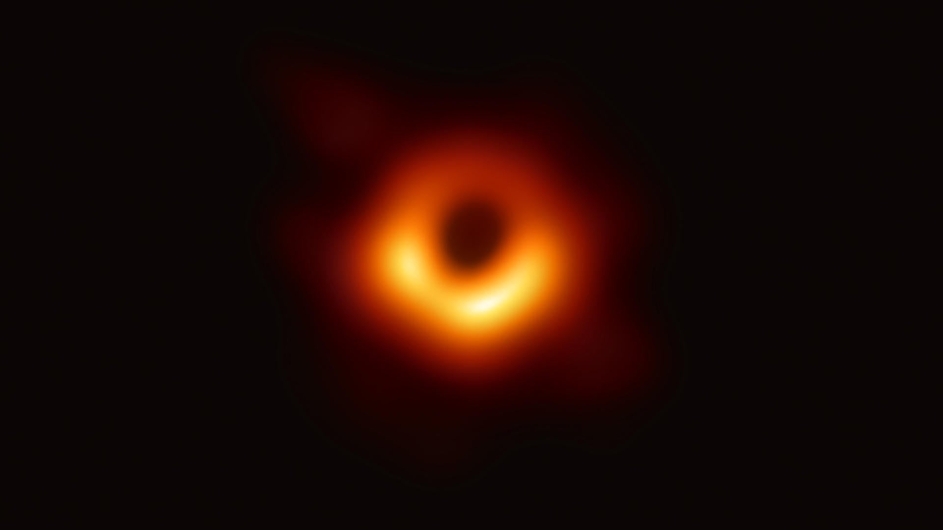 Black hole image, showing a red and orange circle of light before it has crossed the event horizon