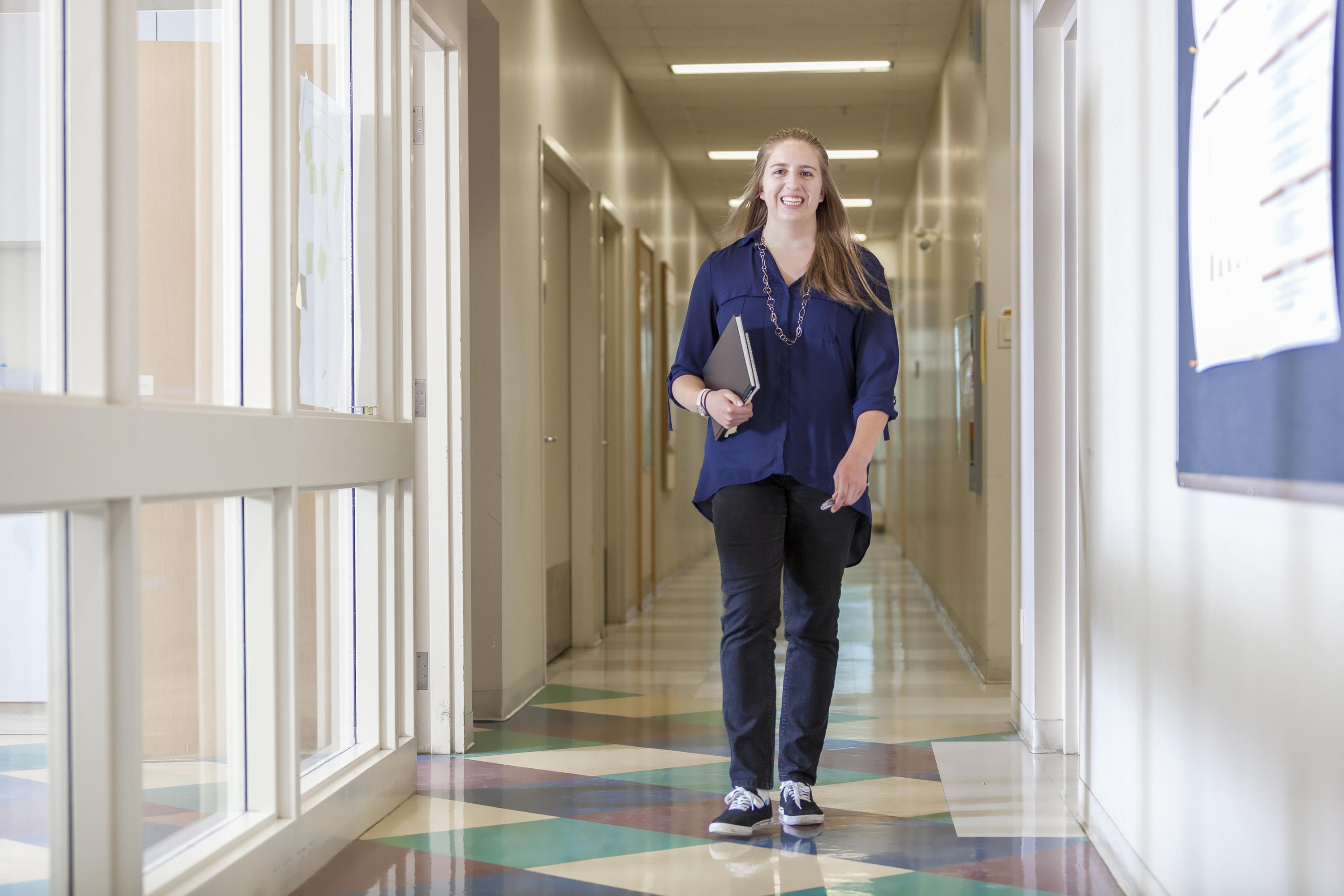 Student walking down hallway in her co-op job.