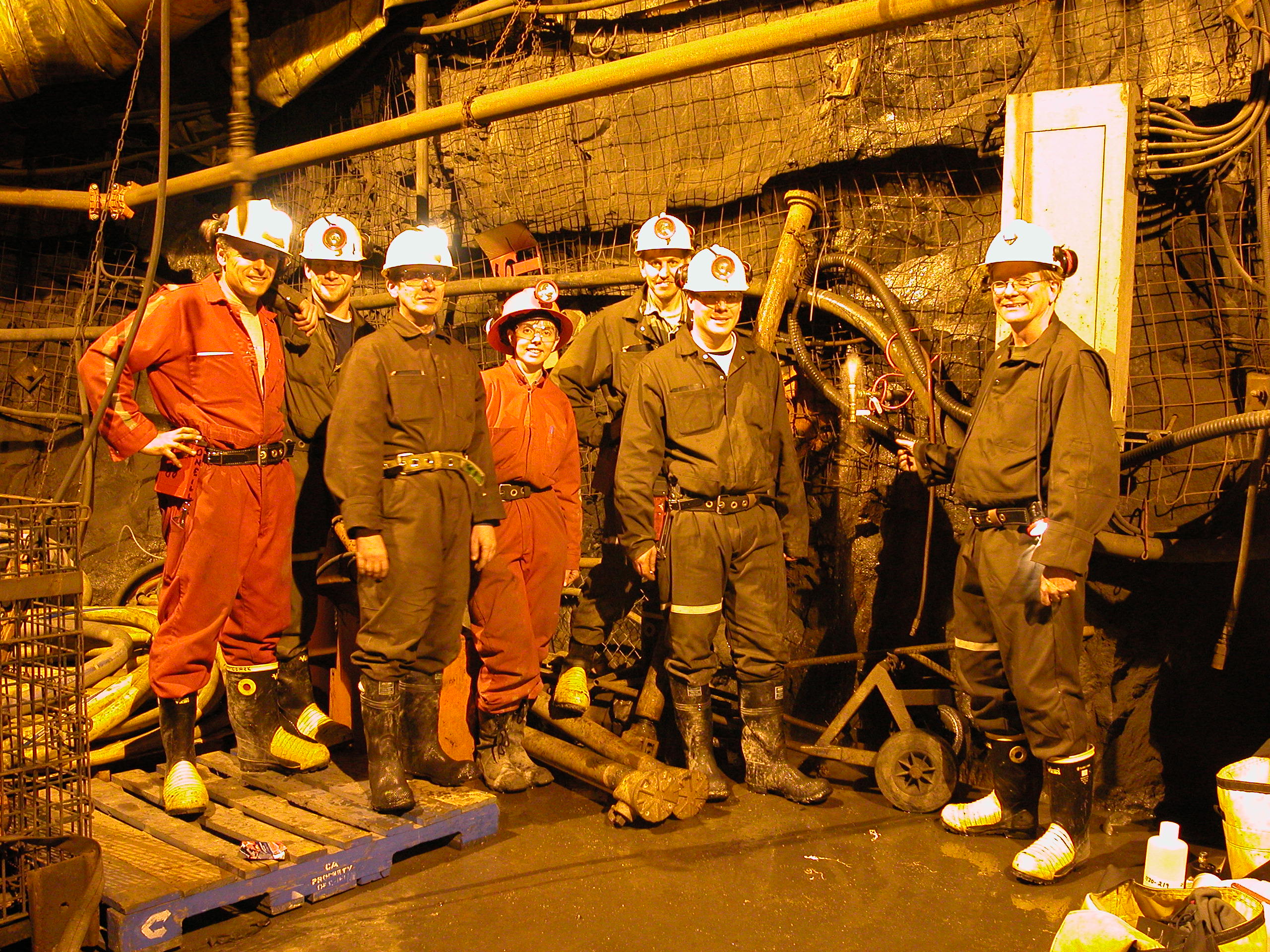 Shaun Frape and 6 other students and collaborators dressed in hard hats and coveralls, and down a mine shaft