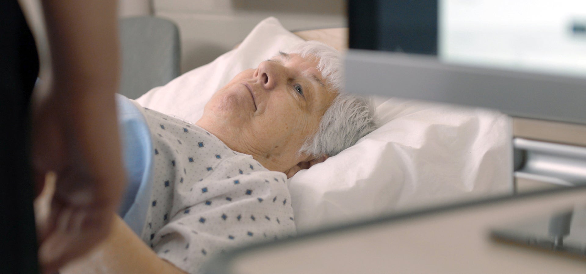 Elderly women lies in a hospital bed