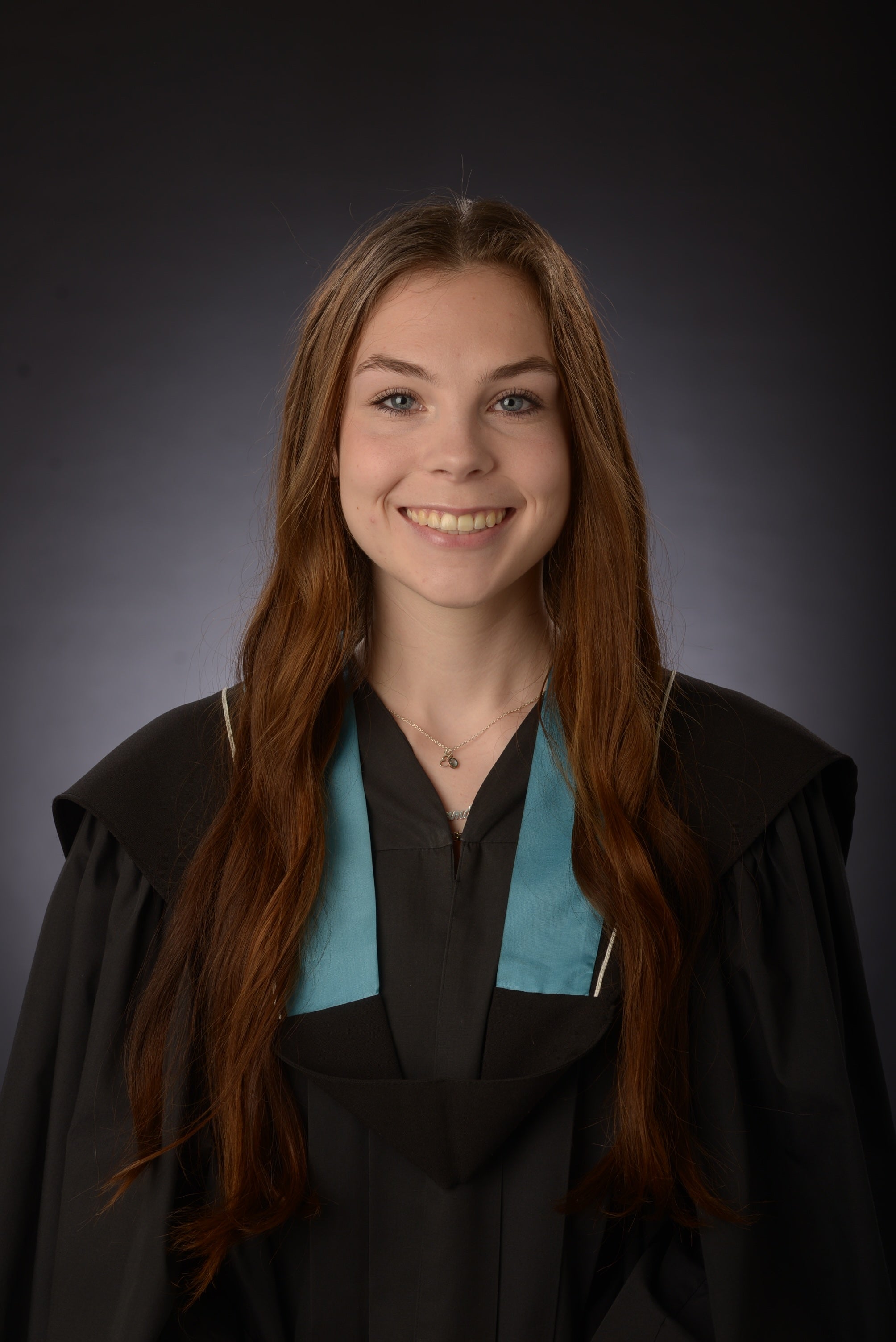 Emma Ross smiling in a formal graduation portrait, wearing a black gown with a blue and black hood, against a dark studio background.