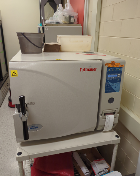 A medium sized rectangular instrument with a large door on the majority of the front. The door has a handle that twists to lock. Multiple buttons are in a panel beside the door, and a receipt-like print out is being produced under the buttons.