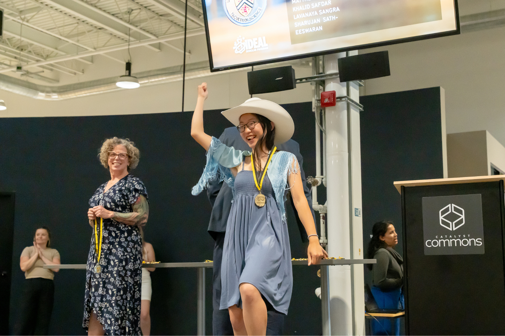 A student celebrating on stage at the IDEAL Scholar ceremony.
