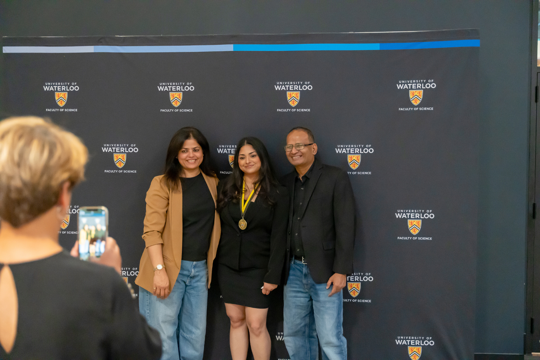 A student with her parents at the IDEAL Scholar ceremony.