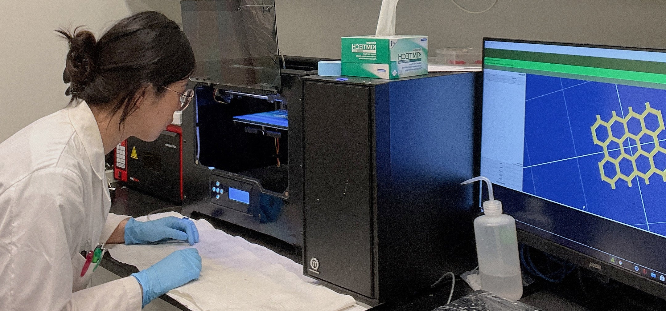Yun Wu working with a 3D printer in the lab.