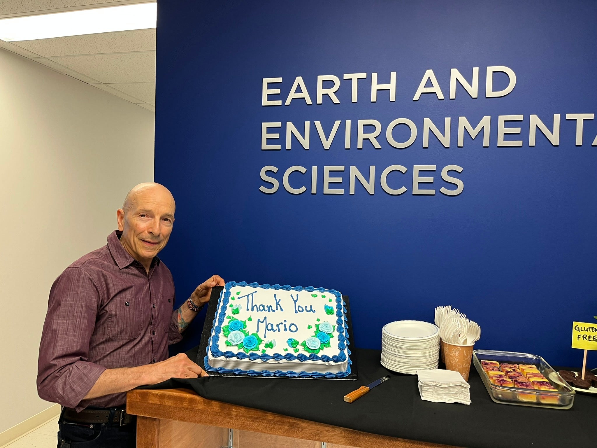 Mario Coniglio stands next to a cake that reads, "thank you."