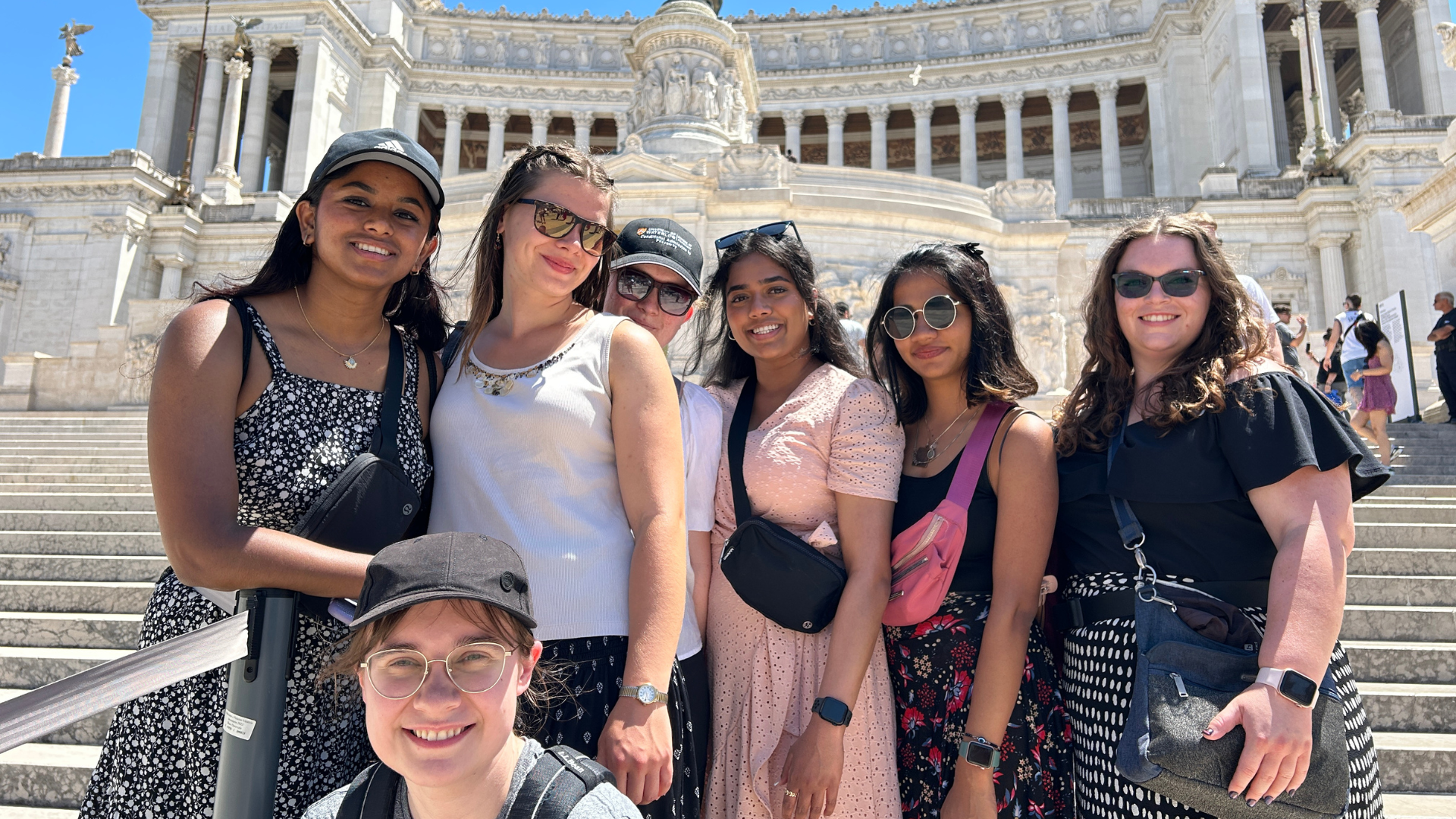 Seven students standing on the steps in front of Altare della Patria in Rome.