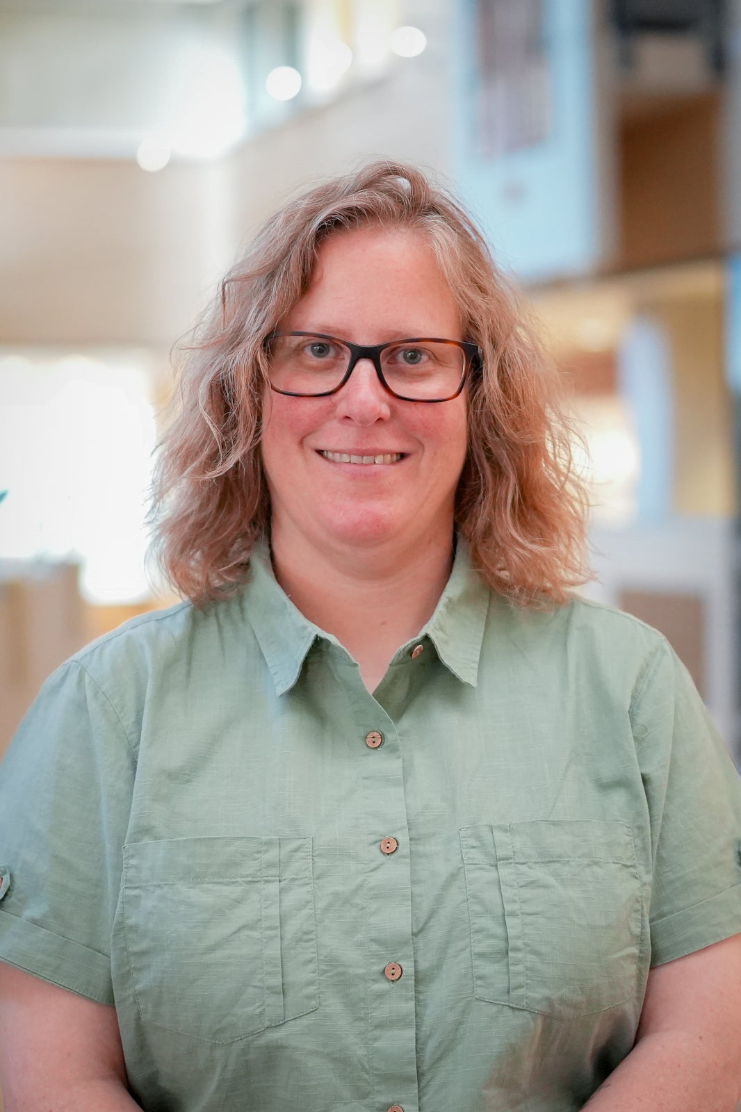 Jen Parks is a professor at Waterloo. She has blonde medium length hair and is wearing glasses and a green button up t-shirt.