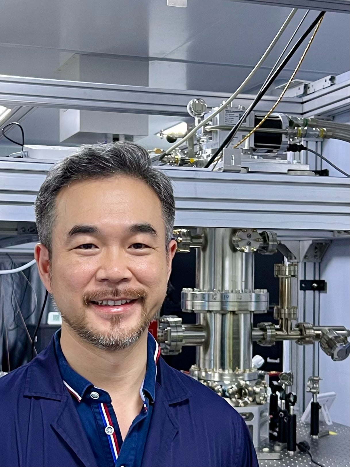 Joe Han in front of a vacuum chamber
