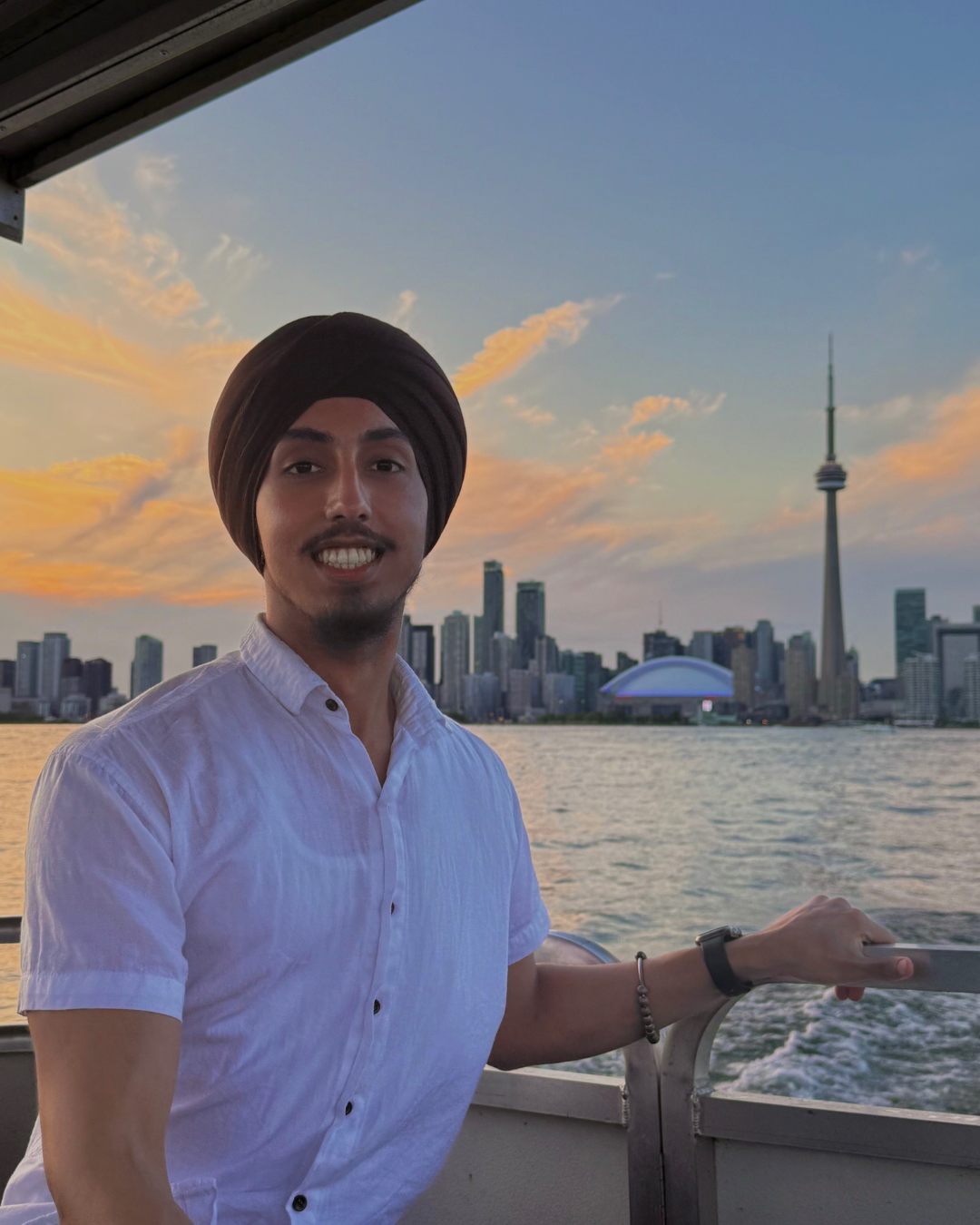 Jovey on a boat on the water in front of the CN Tower.