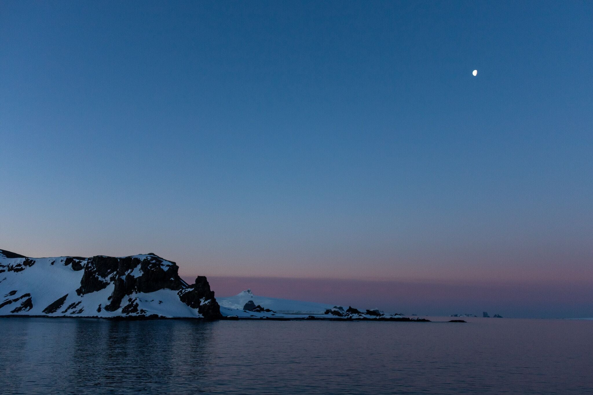 Moon over Half Moon Island, Antarctica. Sunset purple sky