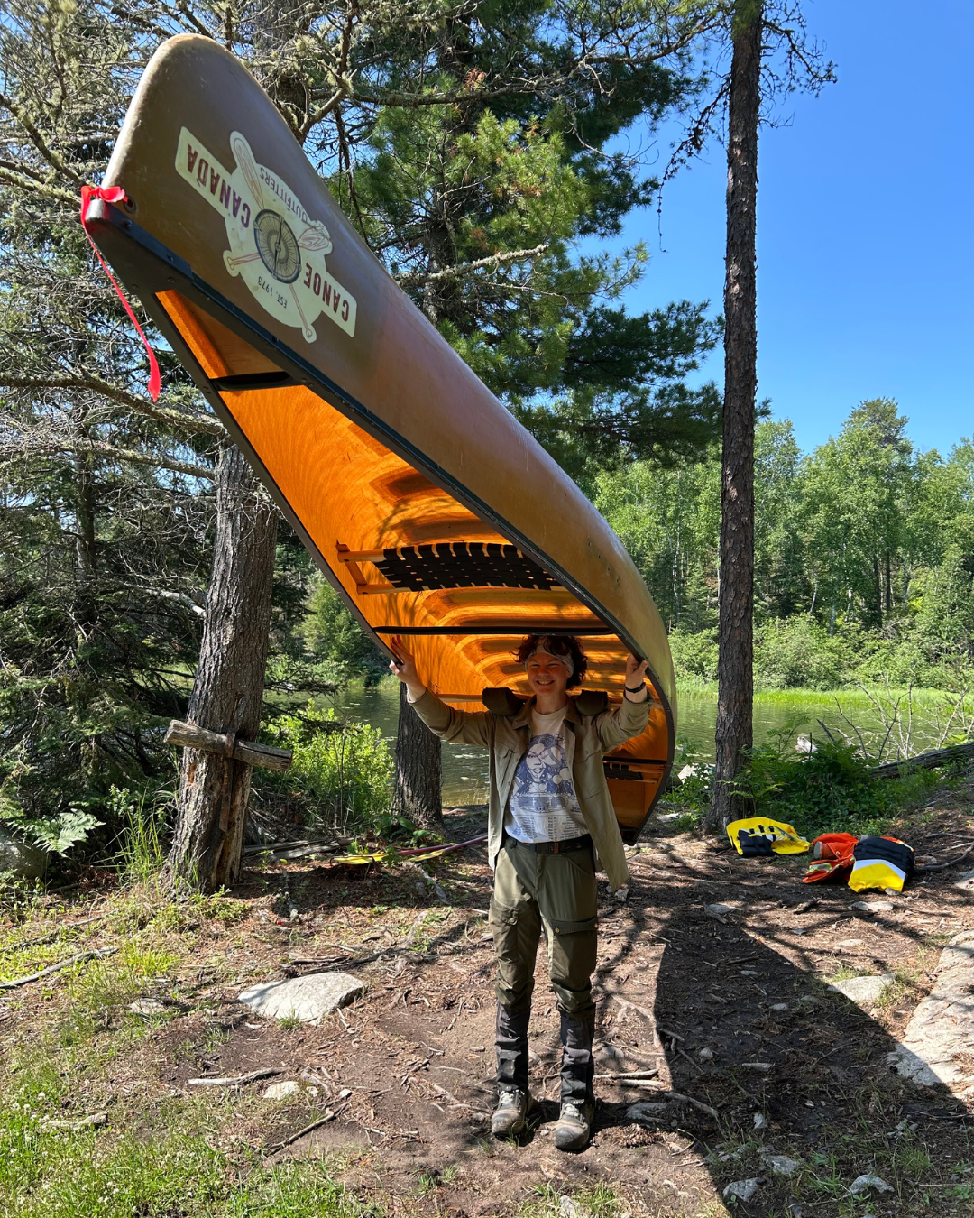 Nathalie carrying a canoe on top of her head.