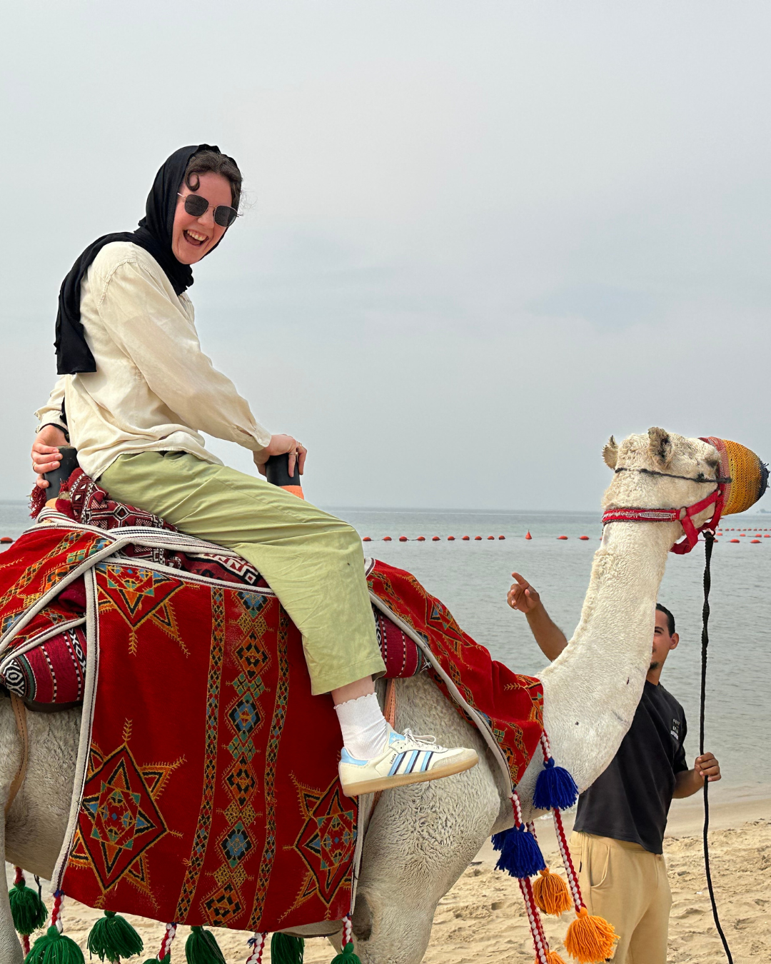 Nathalie riding a camel in Saudi Arabia.