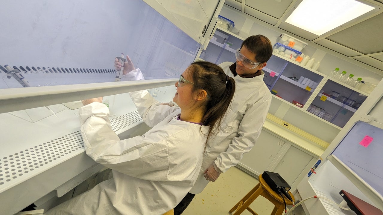 Dr. Brian Kendall overseeing a student conducting an experiment in the lab. 