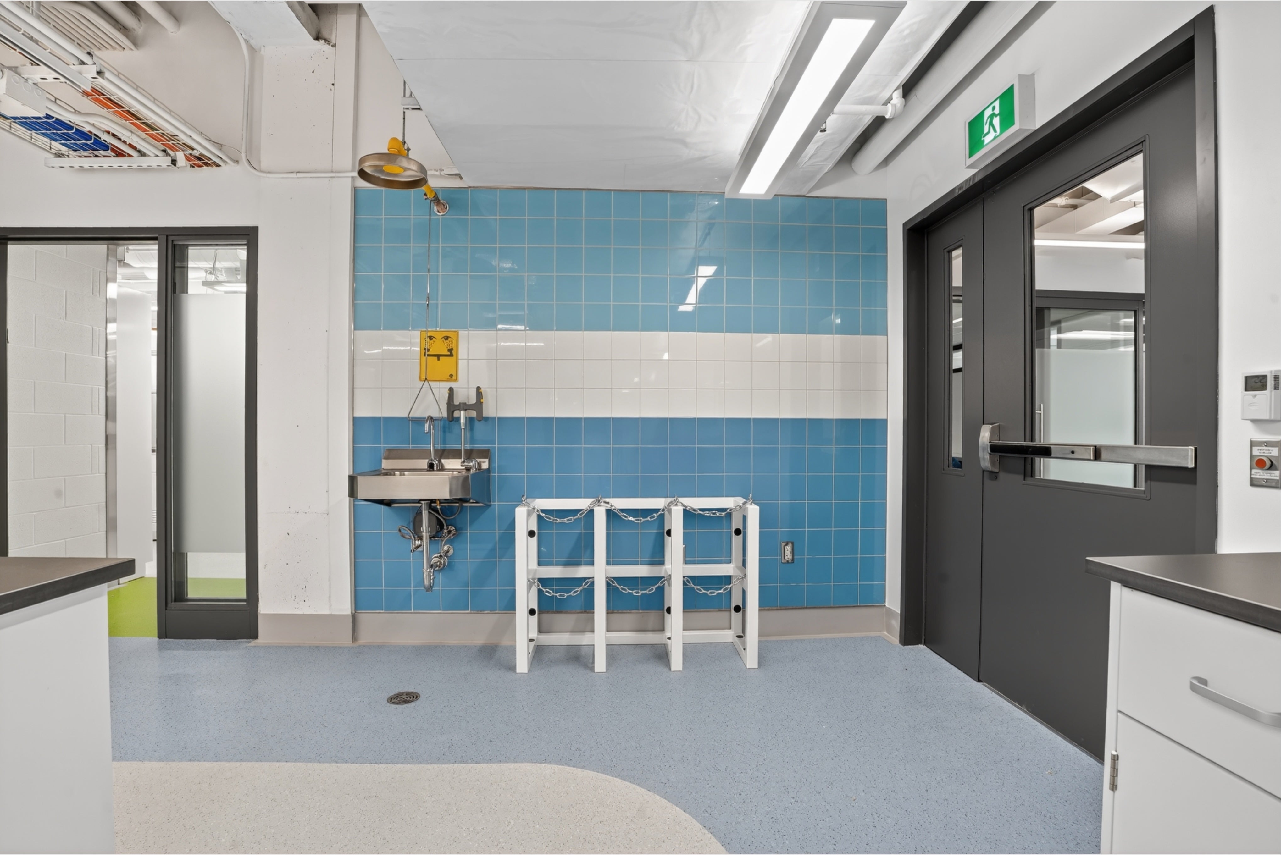 Green labs in ESC, eye wash station against a blue wall. 