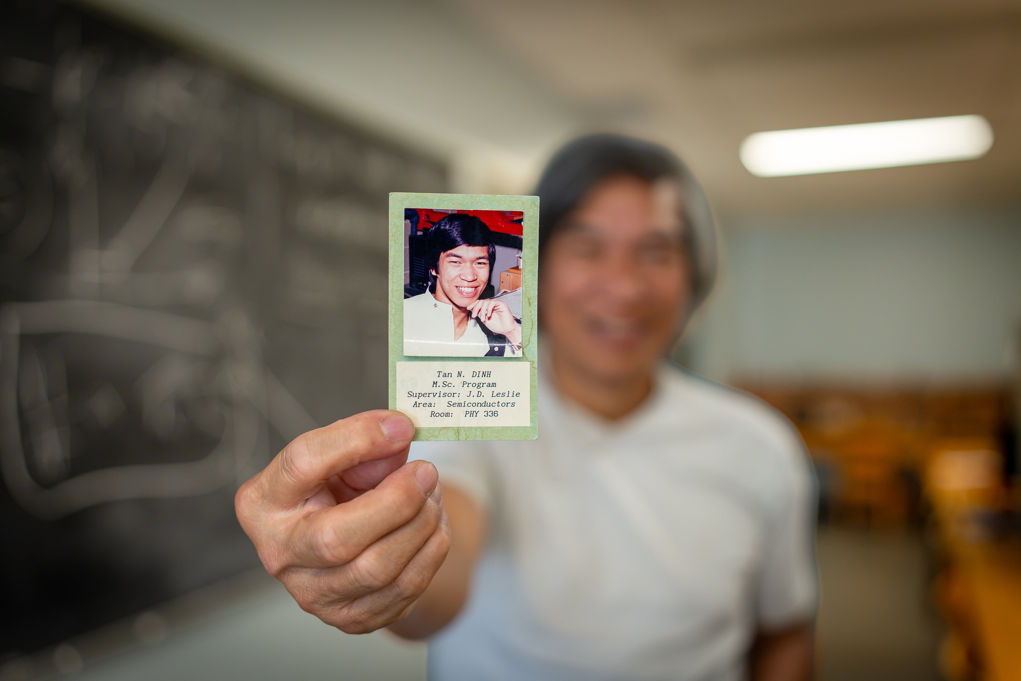 Tan Dinh holds a photo of himself from his time as a graduate student at Waterloo.
