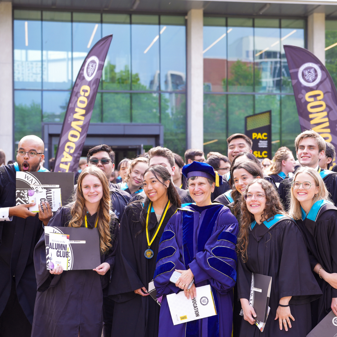 A group of students posing with their caps and gowns at graduation. 